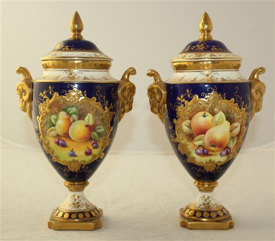 A pair of Coalport fruit painted pedestal vases and covers, post war, 24cm